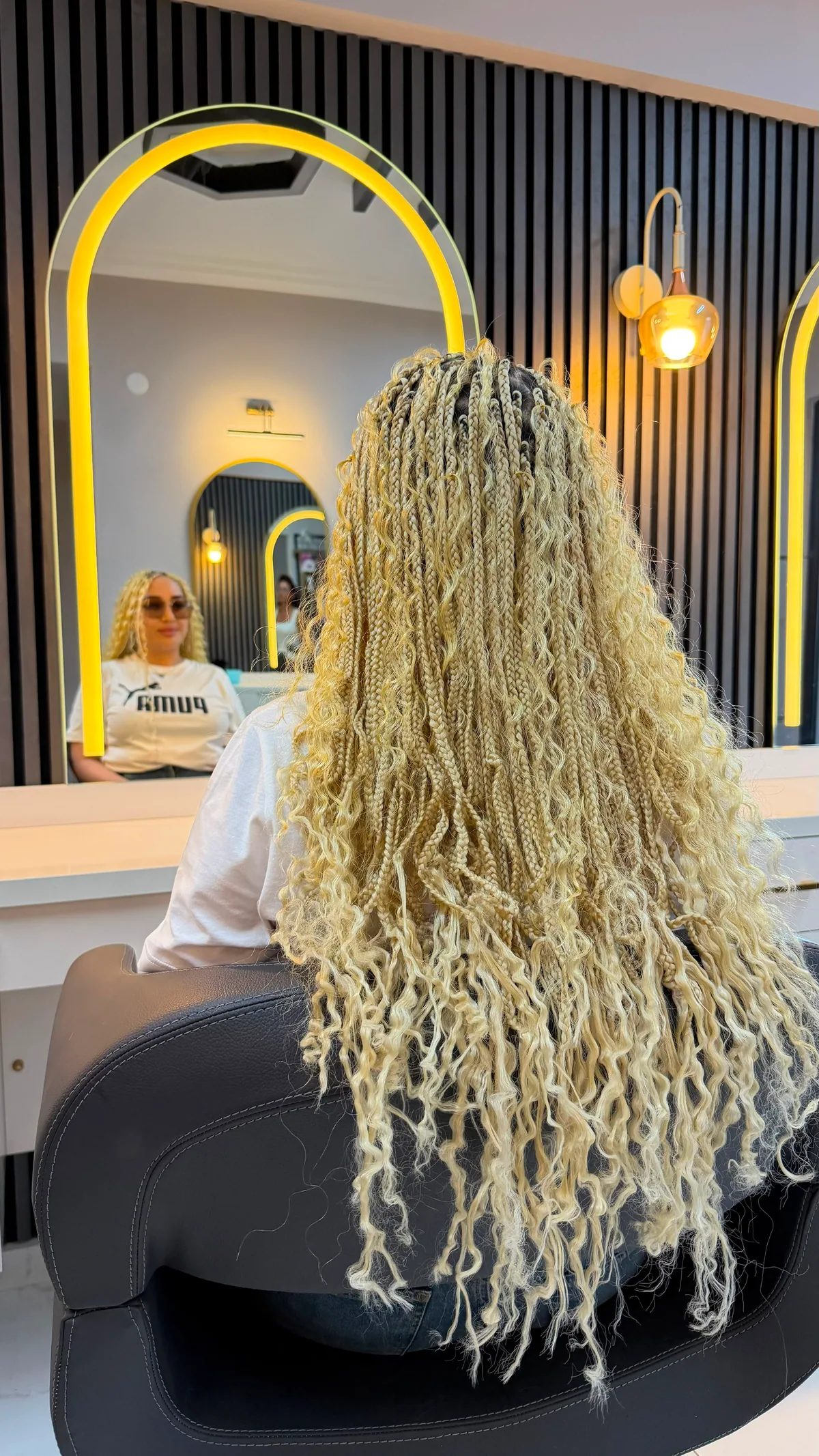 Sarı kıvırcık Afrika örgüsü modelinin aynalı salon alanında arkadan görünümü